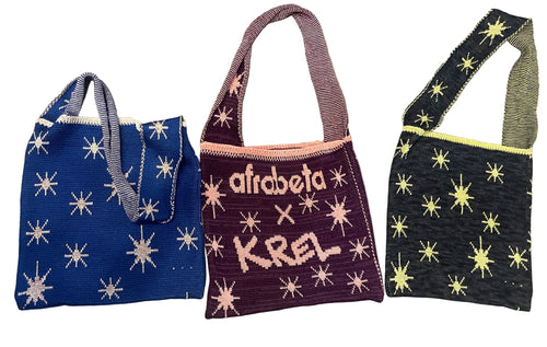 Three knit tote bags with glow-in-the-dark stars and text 'afrobeta' and 'KREL' on them