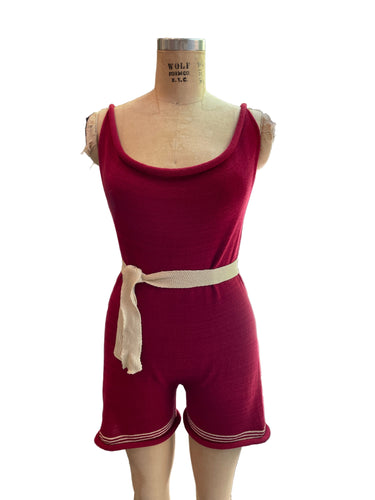 A mannequin displaying a vintage style red and white striped swim tank romper with a belt.